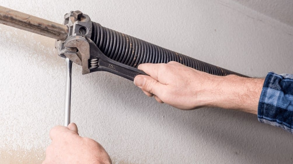 a man fixing a garage door spring